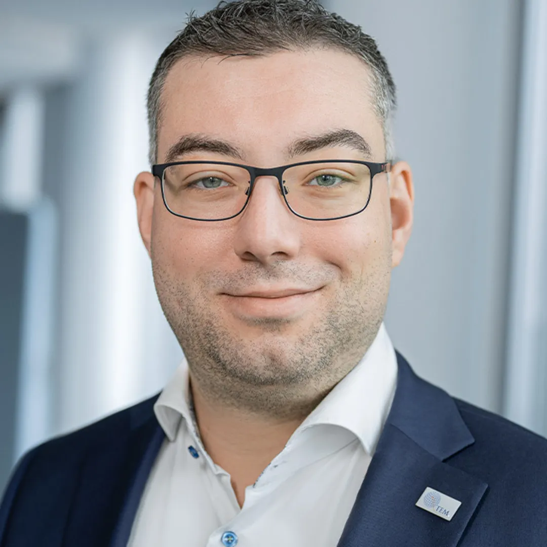 a man wearing glasses and a suit