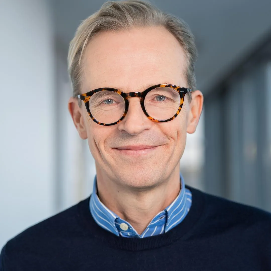 Ein Mann mit Brille und lächelnd