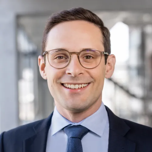 a man wearing glasses and a suit