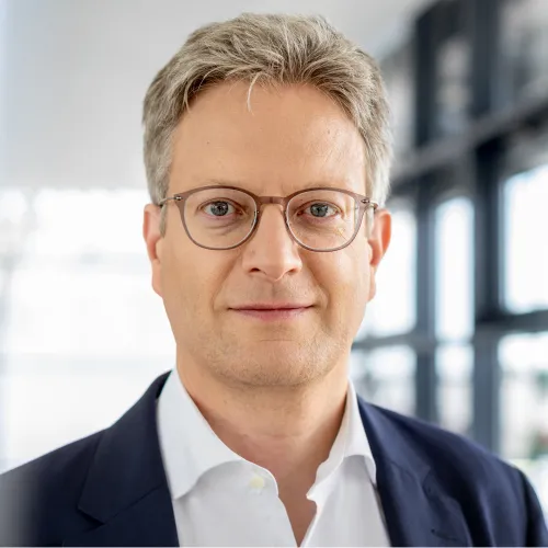 a man wearing glasses and a suit