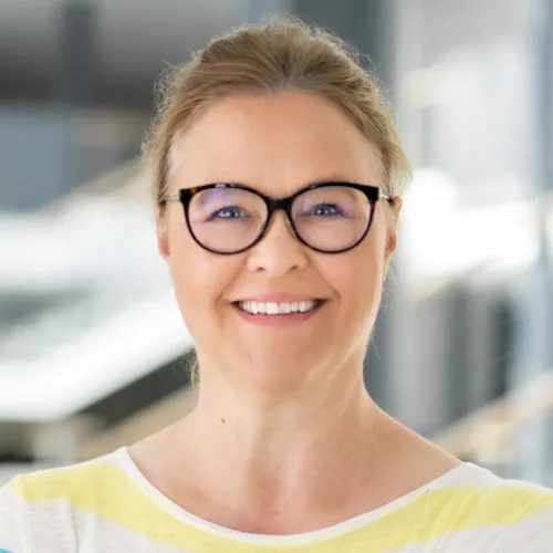 a woman wearing glasses smiling