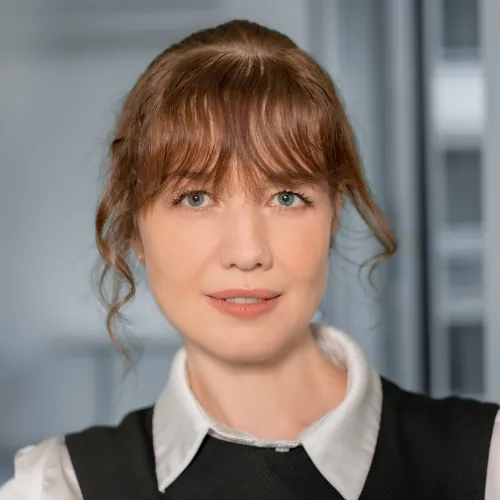 a woman with red hair and a black vest