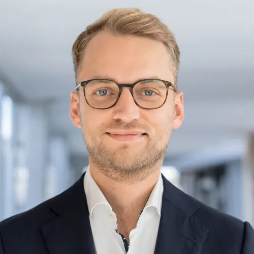 a man wearing glasses and a suit