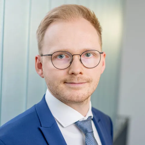 a man wearing glasses and a suit