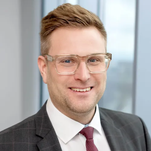 a man wearing glasses and a suit