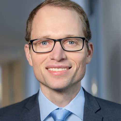 Ein Mann mit Brille und Anzug