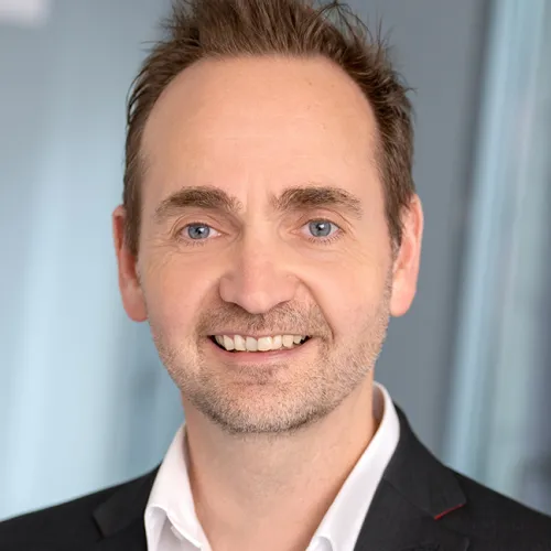 Ein Mann, der in die Kamera lächelt