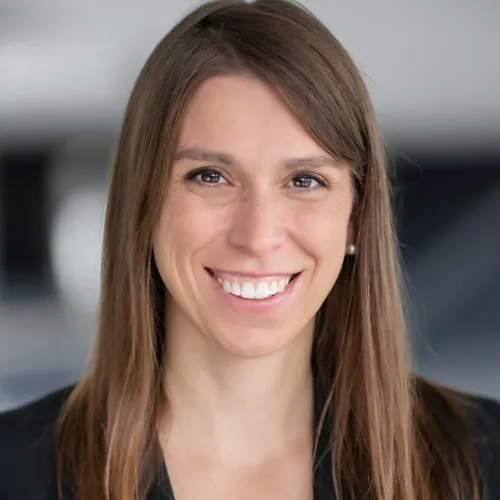 Eine Frau, die in die Kamera lächelt