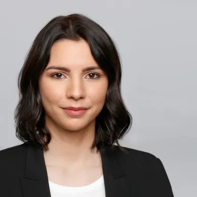 a woman with dark hair wearing a black jacket