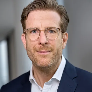 Ein Mann mit Brille und Anzug